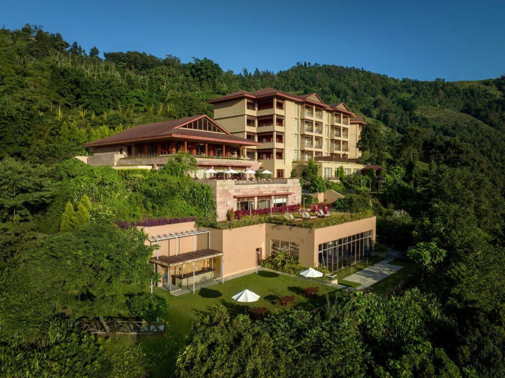 Luxury hillside resort surrounded by lush greenery and mountains for hotel video production.